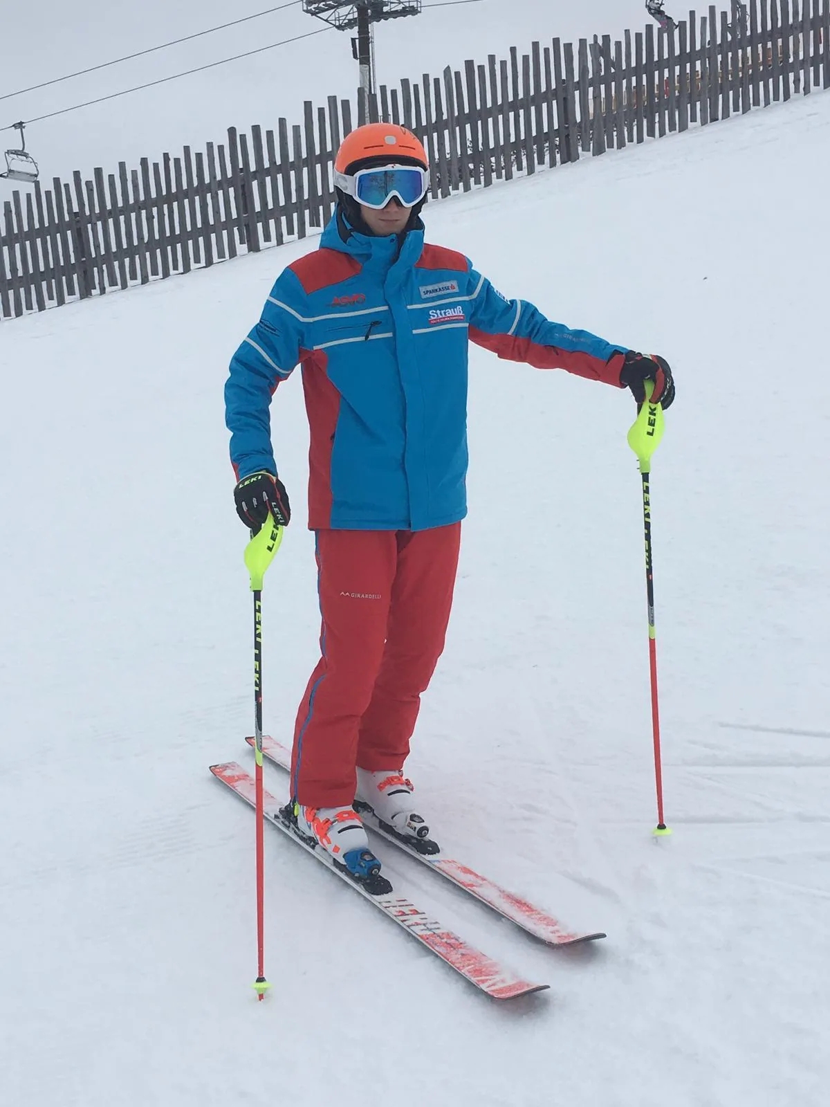 Person in einheitlicher Dienstkleidung auf Skiern an der Piste