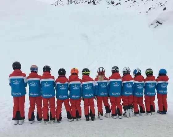 Kindergruppe einer Skischule in einheitlicher Teambekleidung